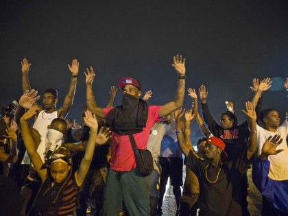 Image: Demonstrators confront police with their arms raised during on-going demonstrations to protest against the shooting of Michael Brown, in Ferguson, Missouri