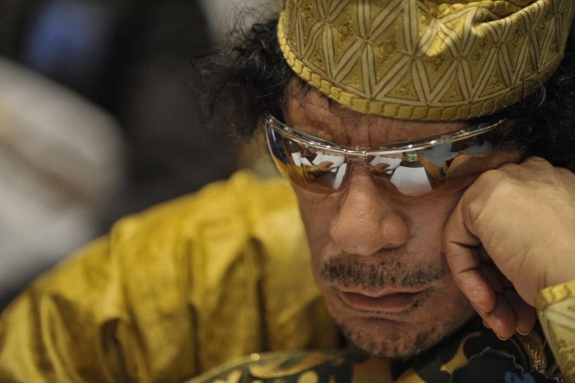 Muammar Gaddafi, Leader of the Revolution of the Great Socialist People’s Libyan Arab Jamahiriya, sits reading in the Plenary Hall of the United Nations (UN) building in Addis Ababa, Ethiopia, during the 12th African Union (AU) Summit