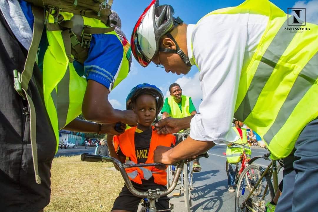 A young biker gets help with his helment.