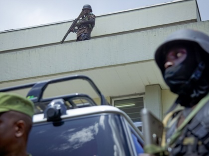 Heavily clad police stand guard over a building