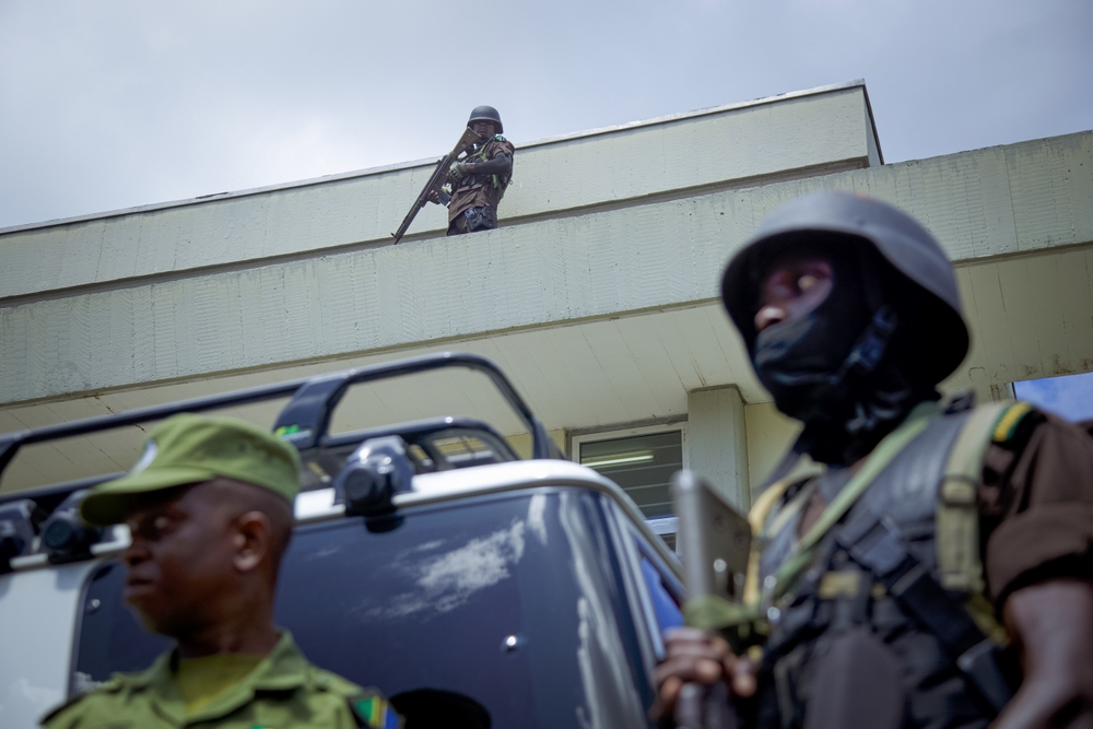 Heavily clad police stand guard over a building