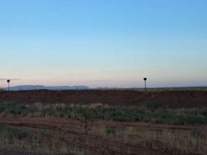 An open field plain at dusk with sunset in the background.