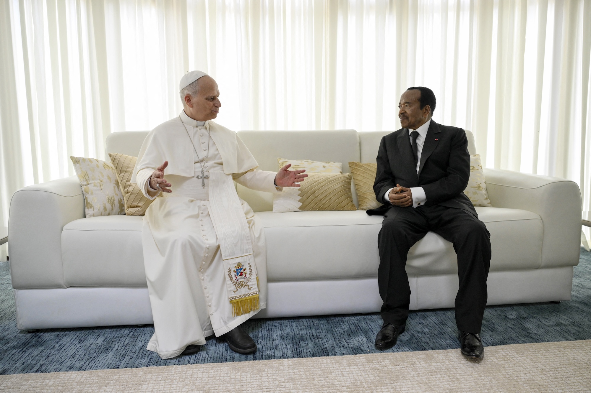 Pope Leo XIV and Paul Biya on a couch.