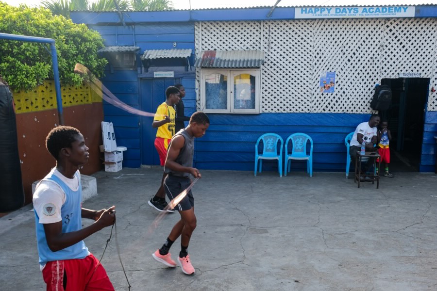 A group of boxers performing skipping drills in an open courtyard.