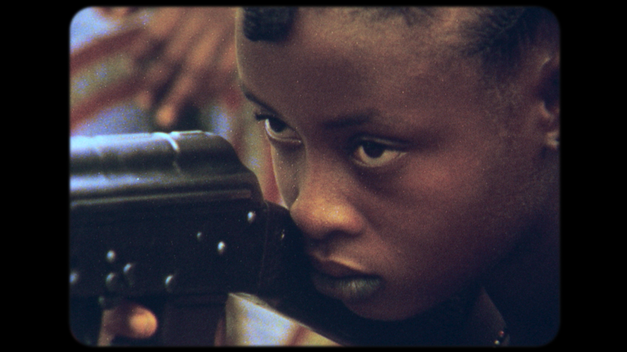 A young woman points a gun.