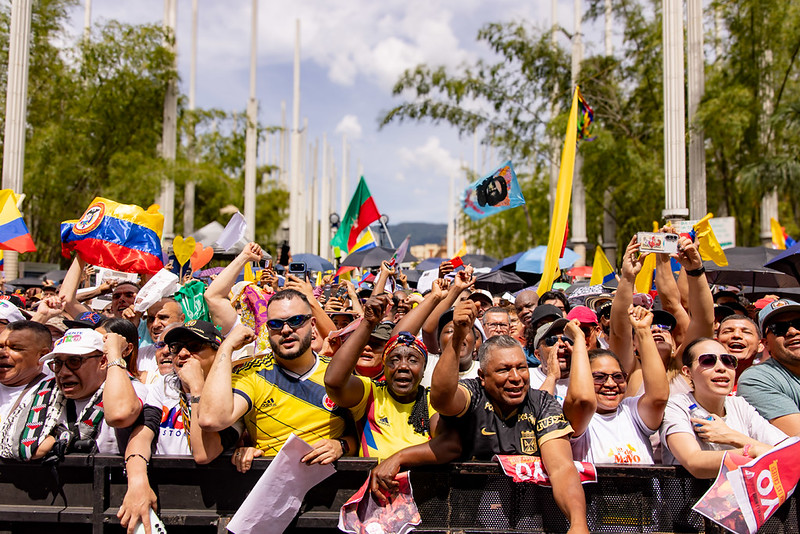 Crowd of demonstrators waving flags and raising their hands during a May Day rally in Medellín, Colombia.