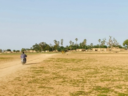 A motorcyclist drives through open, dry grassland in Tilembeya, Mopti, Mali.