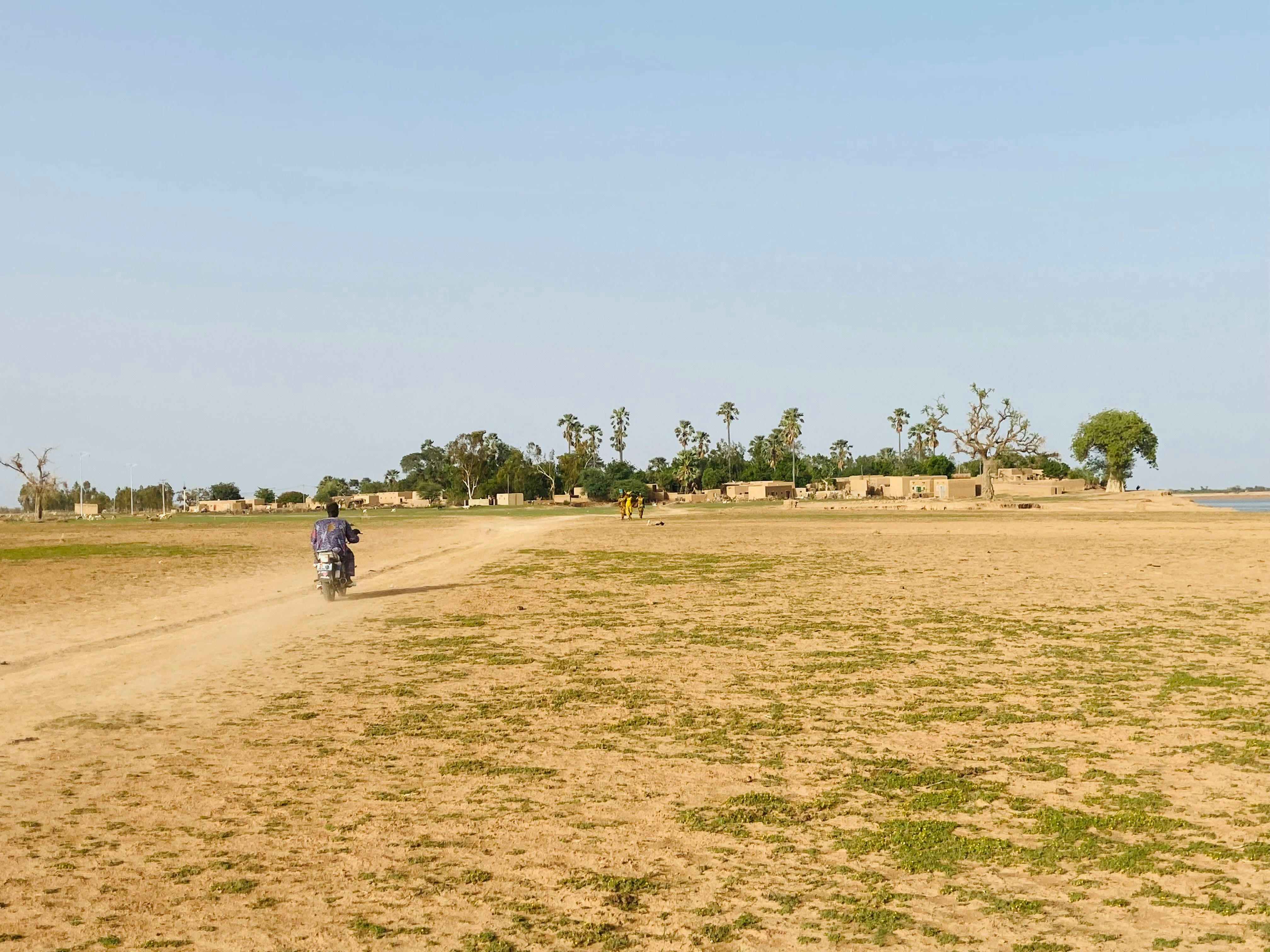 A motorcyclist drives through open, dry grassland in Tilembeya, Mopti, Mali.