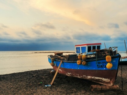 A colorful fishing boat resting on the coastline in Maio, Cape Verde.