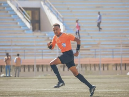 A referee running through a field.