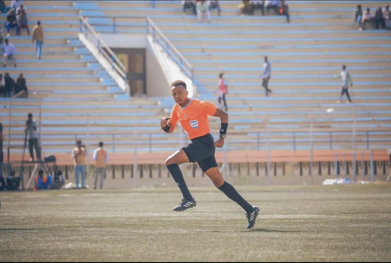 A referee running through a field.