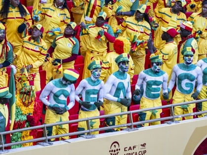 Fans of Senegal’s national football team cheer in the stands at the Africa Cup of Nations, with several supporters spelling out “SENEGAL” using body paint.