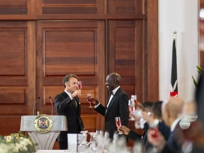 President William Ruto of Kenya and President Emmanuel Macron of France participate in a toast in a fancy ballroom.