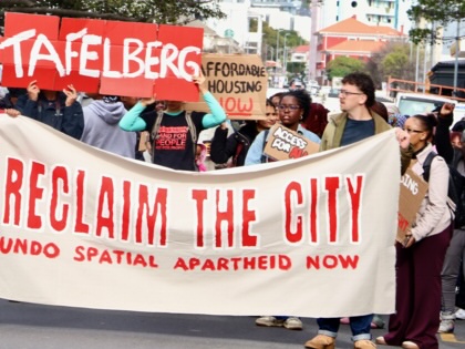 Housing activists march through Sea Point carrying a large banner reading “Reclaim the City: Undo Spatial Apartheid Now” alongside placards calling for affordable housing and the redevelopment of the Tafelberg site.