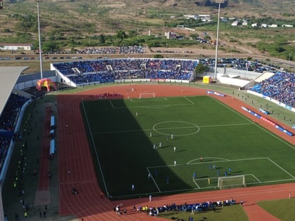 Aerial view of Cabo Verde’s Estádio Nacional filled with supporters during an international football match, with mountains rising behind the stadium as play unfolds on the pitch.