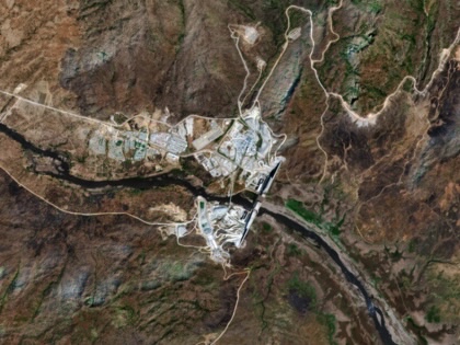 Satellite image of the Grand Ethiopian Renaissance Dam spanning the Blue Nile in a mountainous, arid landscape, with access roads and construction areas visible around the site.