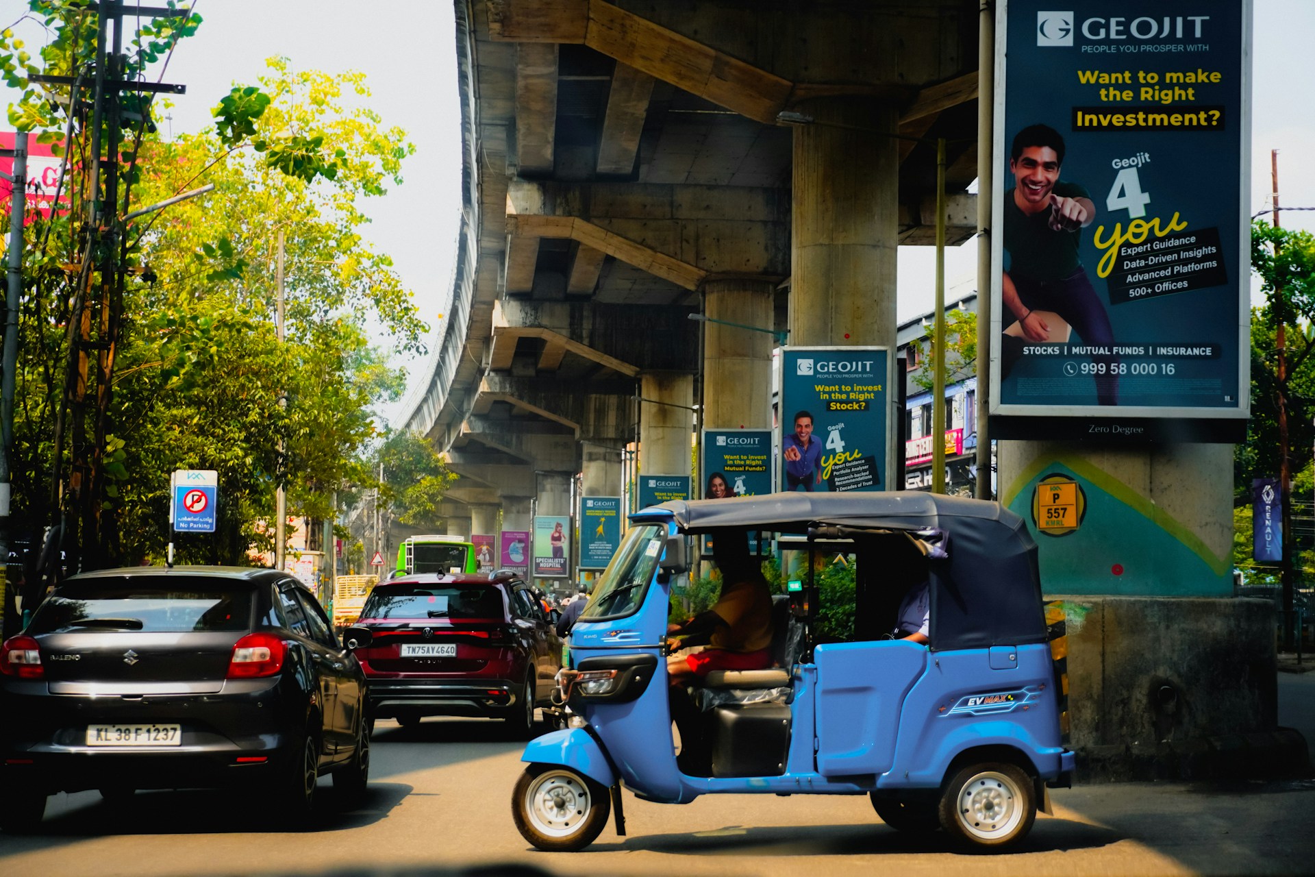 A rickshaw passes by an expressway bridge in India.
